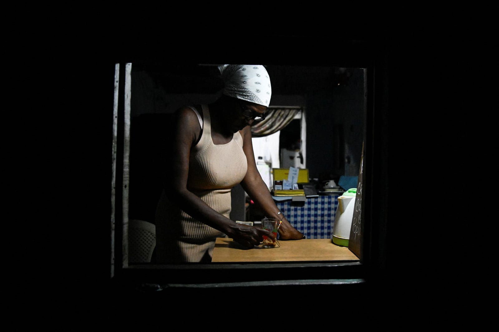 A woman sells coffee from the window of her home during a mass blackout in Havana, Cuba