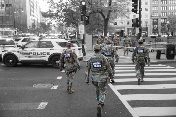National Guard members walk near a cordoned-off area near the White House on November 26, 2025 | REUTERS/Nathan Howard, edited by Russell Nystrom